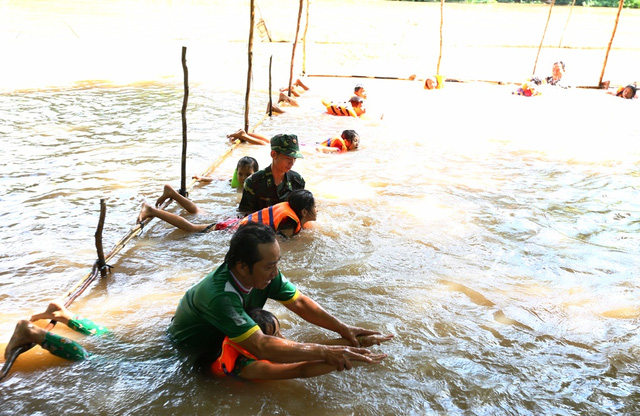 Thầy giáo và các chiến sĩ bộ đội biên phòng Đồn Bình Thạnh dạy bơi cho các em nhỏ. (ảnh: Phú Quí)